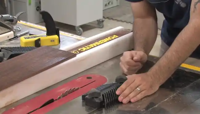 Can a featherboard help prevent kickback on a table saw